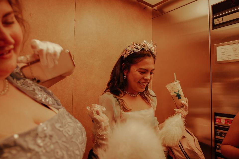 Two smiling women are all dressed up for a dress ball.