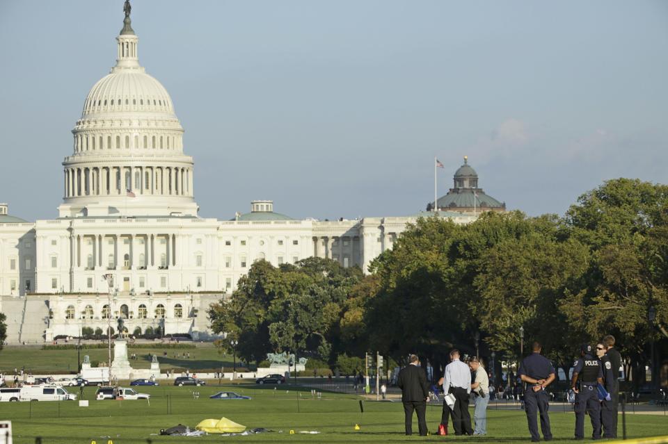 Law enforcement officials investigate the scene where a man set himself on fire in front of the U.S. Capitol on the U.S. National Mall in Washington