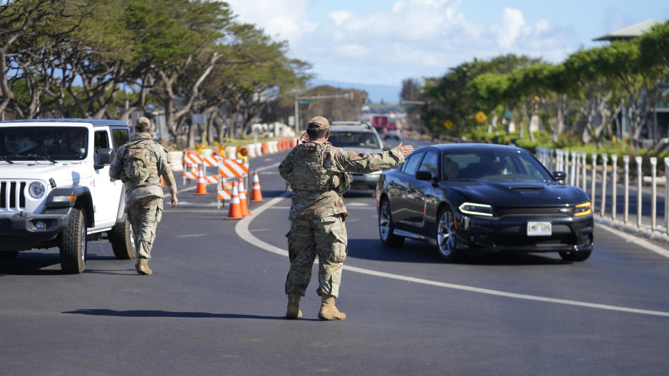 National Guard personnel direct traffic away from the wildfire-damaged areas in Lahaina, Hawaii, Sunday, Aug. 13, 2023, following wildfire that caused heavy damage. (AP Photo/Rick Bowmer)