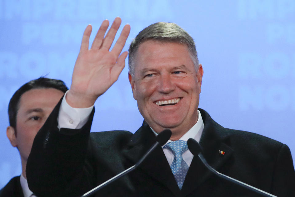 Romanian President Klaus Iohannis waves after exit polls were published, in Bucharest, Romania, Sunday, Nov. 24, 2019. An exit poll by the IRES independent think tank predicts Iohannis getting 66.5 % of the votes, with 33.5% for Social Democratic Party leader Viorica Dancila, a former prime minister. (AP Photo/Vadim Ghirda)