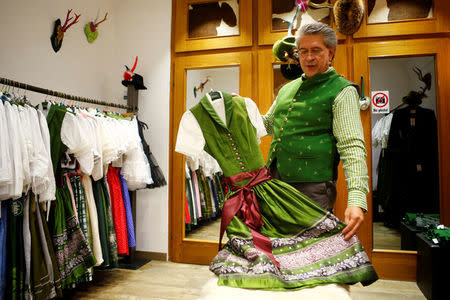 The owner of Witzky Trachten, Wolfgang Witzky, shows a traditional Dirndl dress in his shop in Vienna, Austria, November 25, 2016. Picture taken November 25, 2016. REUTERS/Leonhard Foeger