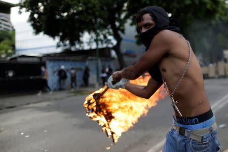 A demonstrator clashes with riot security forces during a rally against Venezuela's President Nicolas Maduro's government in Caracas, Venezuela, July 22, 2017. REUTERS/Ueslei Marcelino