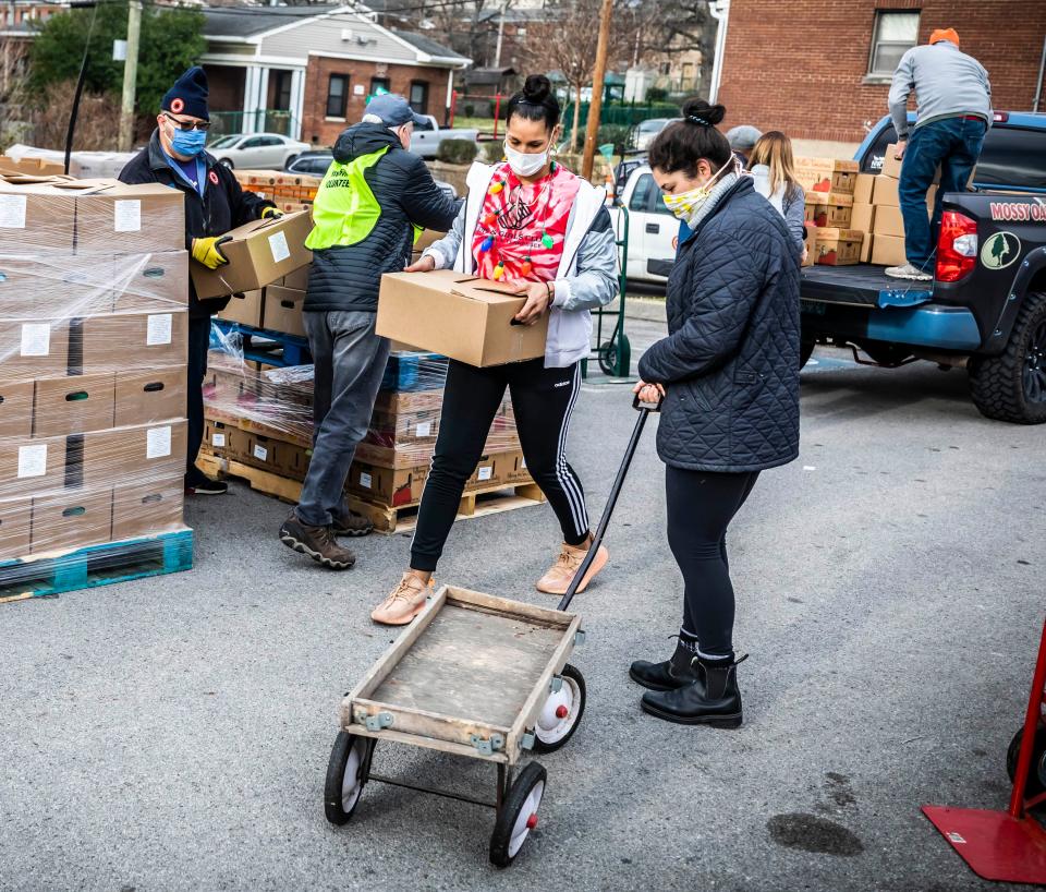 Sharde Burkhead, center, director of The Andrew Jackson Boys and Girls Club, works with volunteers as part of a coordinated effort with The Rotary Club of Nashville, The Andrew Jackson Boys and Girls Club, Second Harvest Food Bank of Middle Tennessee and MDHA to deliver food boxes to MDHA housing residents Saturday, December 19, 2020.