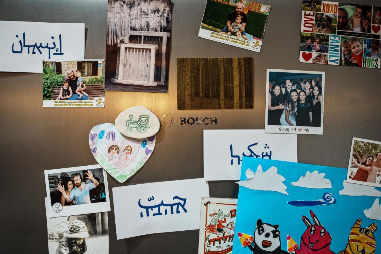 Photographs and cards, including a few bearing blue script, on a fridge door