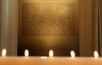 Candles burn in front of a plaque with the names of the victims of flight PS752, at the High Commission of Canada in London, Thursday, Jan. 16, 2020. The Foreign ministers of Canada, The Netherlands, Sweden, Ukraine and Afghanistan are meeting as part of the International Coordination and Response Group for the families of the victims of PS752 flight crashed shortly after taking off from the Iranian capital Tehran on Jan. 8, killing all 176 passengers and crew on board. (AP Photo/Frank Augstein)