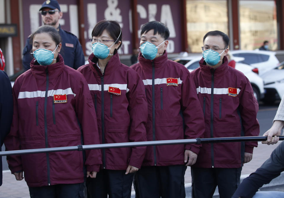 Medics and paramedics from China arrive at the Malpensa airport of Milan, Wednesday, March 18, 2020. Some 37 between doctors and paramedics were sent along with some 20 tons of equipment, and will be deployed to different hospitals in Italy's most affected area. For most people, the new coronavirus causes only mild or moderate symptoms. For some it can cause more severe illness, especially in older adults and people with existing health problems. (AP Photo/Antonio Calanni)
