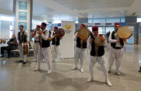 FILE PHOTO: Members of a traditional music group perform as tourists traveling with the Thomas Cook travel agency arrive at the Enfidha Airport in Enfidha