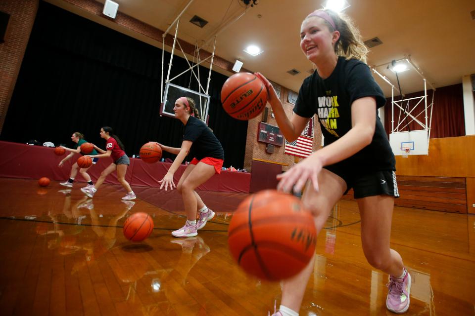 Bridget Markey and fellow Bishop Stang High School girls basketball team members dribble two balls as they prepare for the upcoming season.