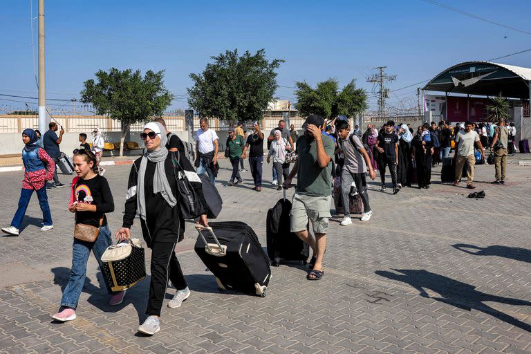 La gente ingresa al cruce fronterizo de Rafah en el sur de la Franja de Gaza antes de cruzar a Egipto el 1 de noviembre de 2023