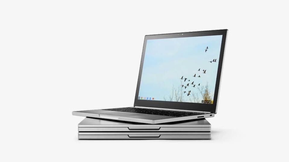 The Google Chromebook Pixel 2015 open atop a pile of laptops.