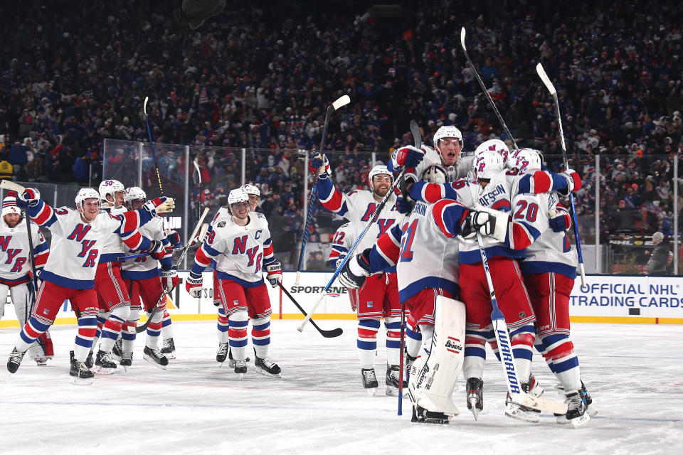 Rangers players celebrate their overtime win in front of nearly 80,000 fans. (Al Bello/Getty Images)