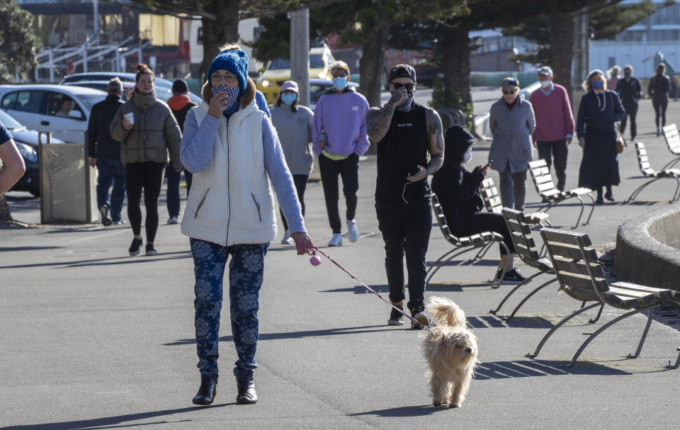 People, some wearing masks, walk along a path in Wellington, New Zealand on Thursday. Source: Mark Mitchell/New Zealand Herald via AP