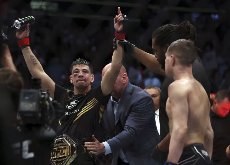 Brandon Moreno raises his arms as he is declared the winner in a mixed martial arts interim flyweight bout against Kai Kara-France at UFC 277 on Saturday, July 30, 2022, in Dallas. (AP Photo/Richard W. Rodriguez)