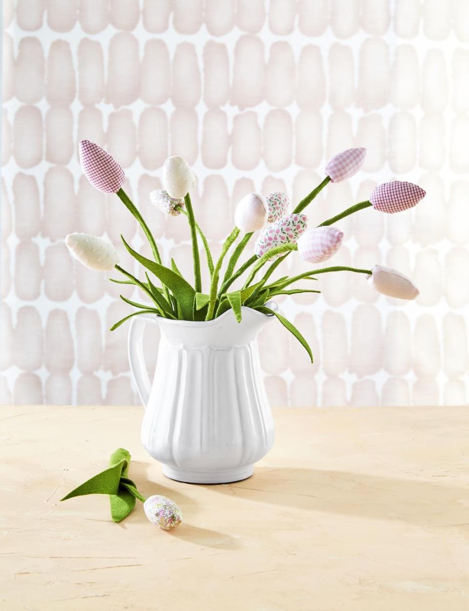 faux tulips with blooms made from pink and white solid, gingham, and floral patterned fabrics attached to wired green felt stems, displayed in white ceramic pitcher