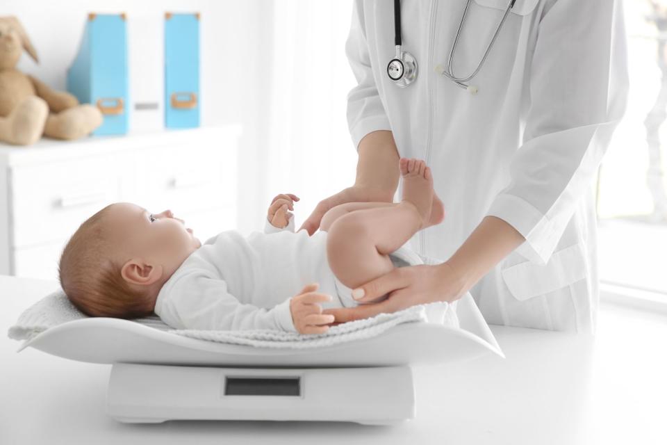 Pediatrician Measuring Baby Weight on Scale