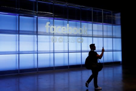 FILE PHOTO: An attendee takes a photograph of a sign during Facebook Inc's F8 developers conference in San Jose