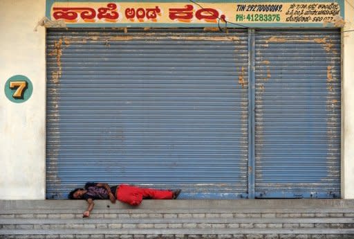 An Indian labourer sleeps in front of closed shops during a nationwide strike in Bangalore. Protests were held across India with effigies of Singh burnt by demonstrators in Bangalore, while strikers blocked some national highways and major rail routes