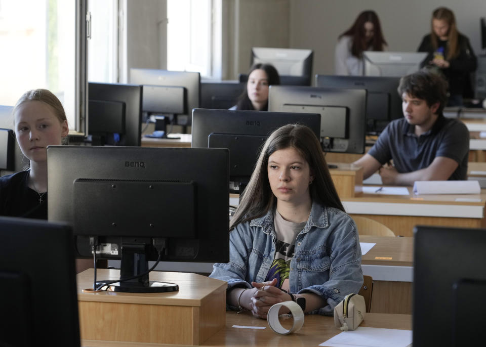 Olha Andrieieva, foreground right, a Ukrainian student in Poland, prepares to take a Ukrainian final state examination at a center in Warsaw, Poland, Wednesday June 7, 2023. Russian forces have destroyed 262 educational institutions and damaged another 3,019 in their invasion of Ukraine, according to government figures. For those who've fled to other countries, schooling is suffering in unprecedented ways, according to families, educators, experts and advocates. The effects of war and relocation combined with the challenges of studying in a new country are compounding educational setbacks for young refugees. (AP Photo/Czarek Sokolowski)