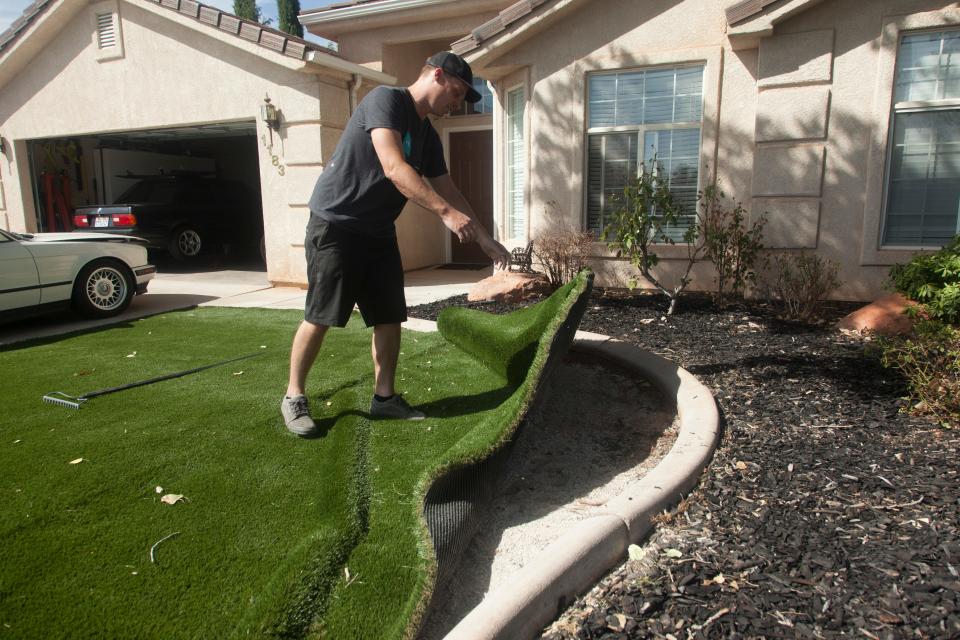 St. George resident Ryan installs artificial turf in front of his home Monday, Sept. 20, 2021.