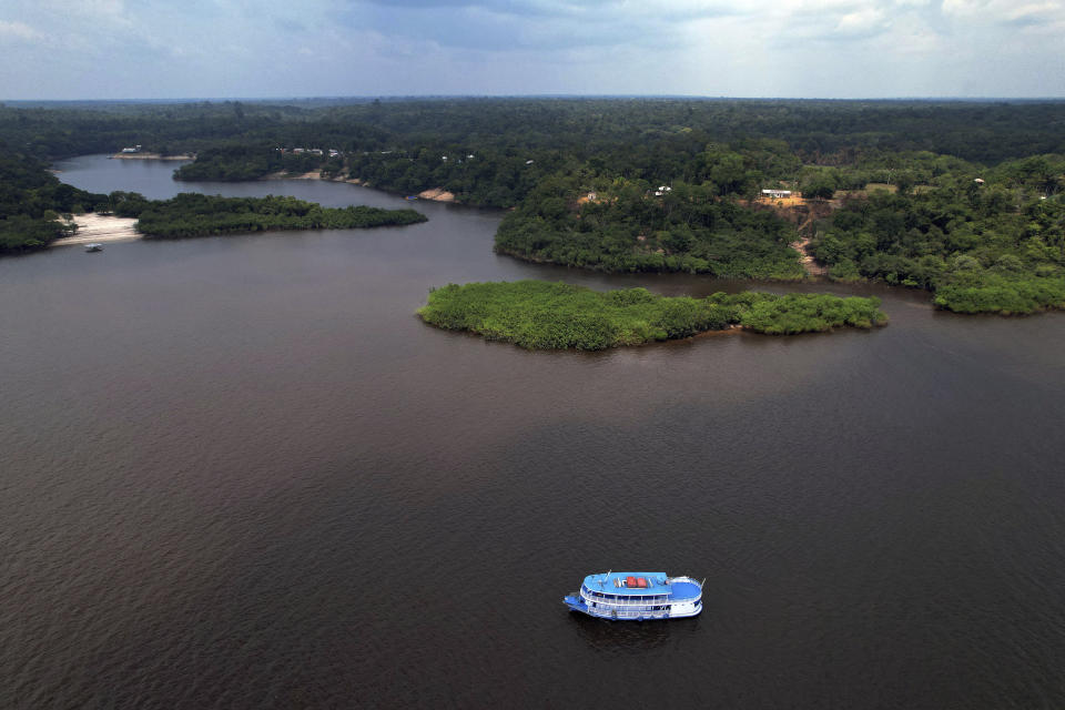 Electoral workers on a boat loaded with electronic voting machines to be taken to voting centers ahead of tomorrow's elections, navigate the Rio Negro, in Manaus, Amazonas state, Brazil, Saturday, Oct. 1, 2022. (AP Photo/Edmar Barros)