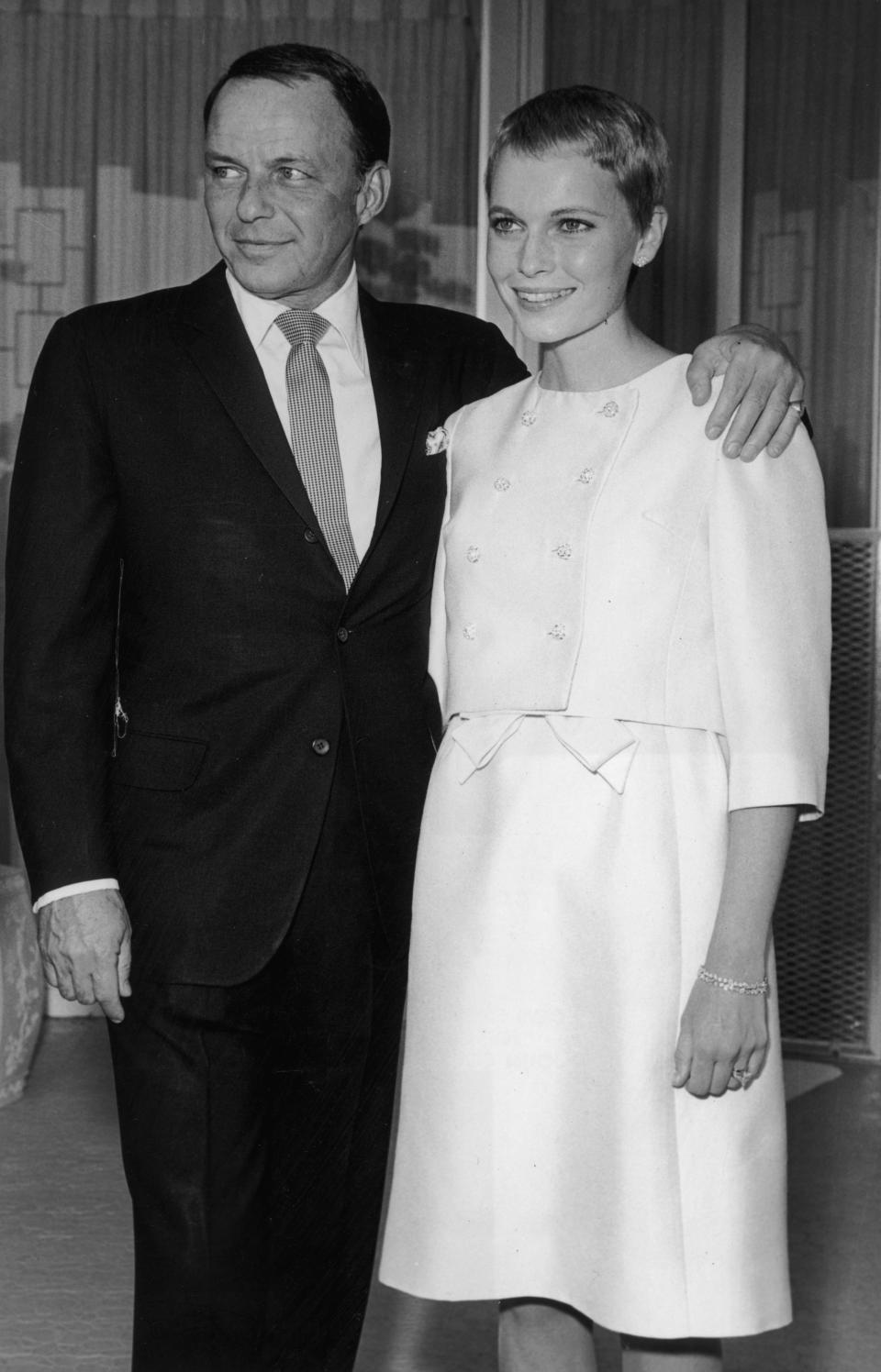 Frank Sinatra wraps his arm around Mia Farrow.