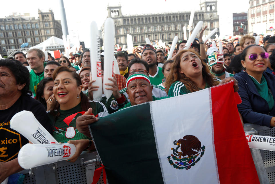 Mexican fans react while watching the broadcast at the Zocalo square.