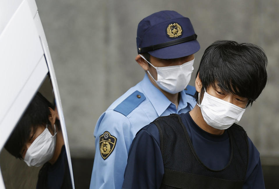 FILE - Tetsuya Yamagami, the attacker who shot former Prime Minister Shinzo Abe, gets out of a police station in Nara, western Japan, on July 10, 2022, on his way to local prosecutors' office. A glimpse of Yamagami's painful childhood has led to a surprising amount of sympathy in Japan, where three decades of economic malaise and social disparity have left many feeling isolated and unease. (Miki Matsuzaki/Kyodo News via AP, File)