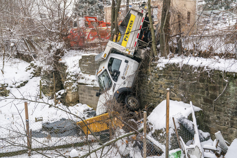 A Pittsburgh Public Works salt truck is shown after sliding off Proctor Way in the South Side Slopes neighborhood in Pittsburgh, Pa., Monday, Feb. 1, 2021. The driver of the truck was unhurt, according to the city public safety department. (Andrew Rush/Pittsburgh Post-Gazette via AP)