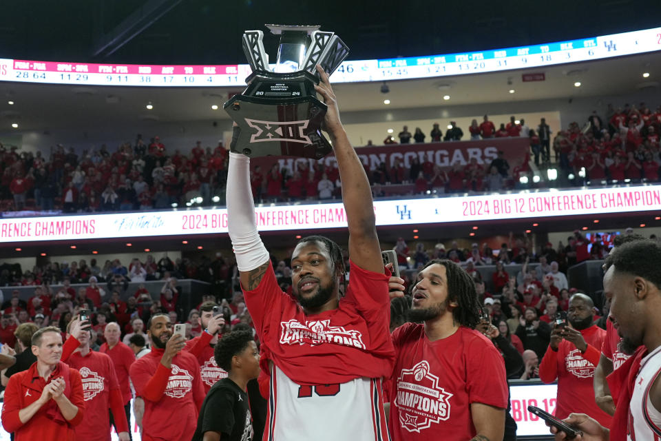 Houston's J'Wan Roberts, center, holds up the trophy after an NCAA college basketball game against Kansas Saturday, March 9, 2024, in Houston. Houston won 76-46 and finished the regular season as the Big 12 Conference Champions. (AP Photo/David J. Phillip)