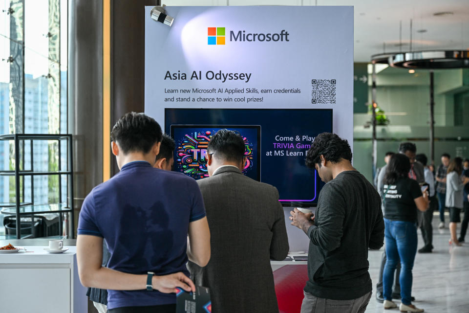Participants check a Microsoft booth before CEO Satya Nadella's speech during an event named Microsoft Build AI Day in Kuala Lumpur on May 2, 2024. Microsoft on May 2, 2024 pledged a $2.2 billion investment in artificial intelligence and cloud computing in Malaysia to help develop the country's AI infrastructure, the tech giant said in a statement. (Photo by Mohd RASFAN / AFP) (Photo by MOHD RASFAN/AFP via Getty Images)