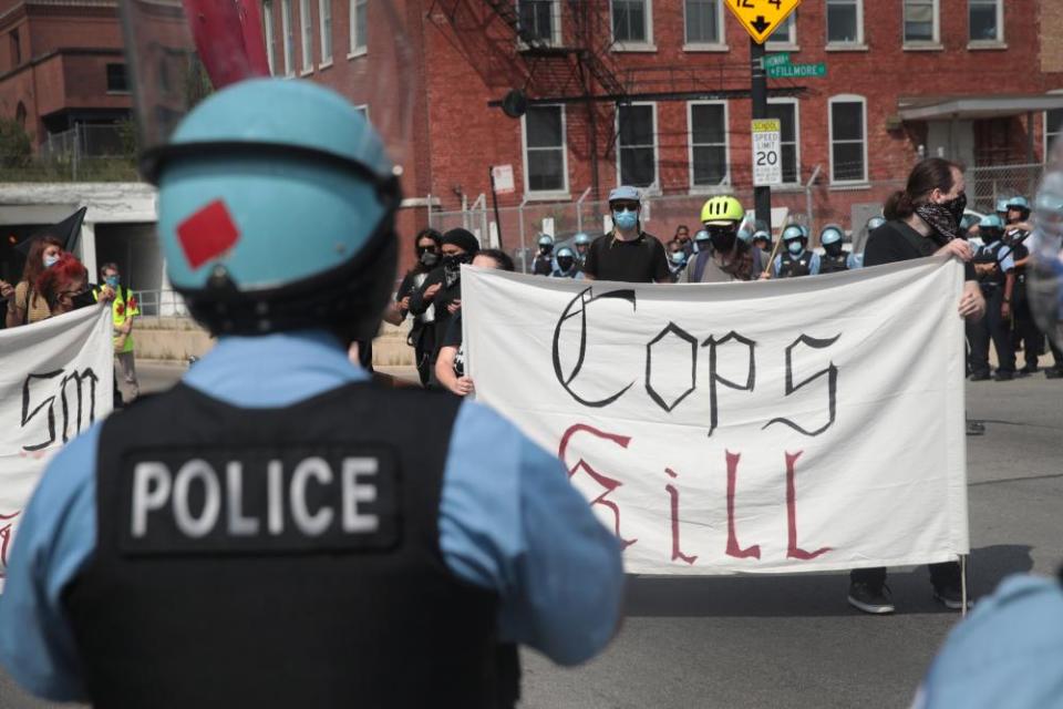 Police stand guard as pro and anti-police demonstrators gather outside of the Homan Square police station in Chicago on 15 August.