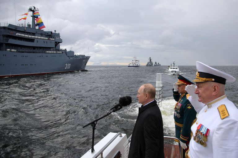 El presidente de Rusia, Vladimir Putin, flanqueado por el ministro de Defensa ruso, Serguei Shoigu, y el comandante en jefe de la Armada rusa, el almirante Nikolai Yevmenov, participa en el principal desfile naval que marca el Día de la Armada rusa, en San Petersburgo el 31 de julio de 2022.
