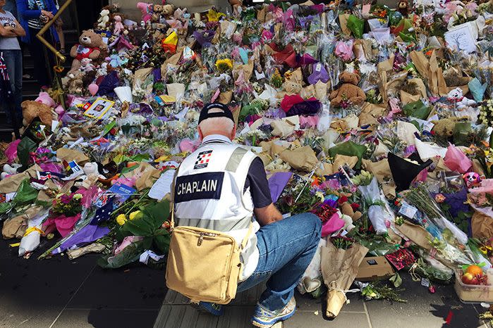 Volunteers remove wilting flowers from the temporary Bourke Street memorial. Source: AAP
