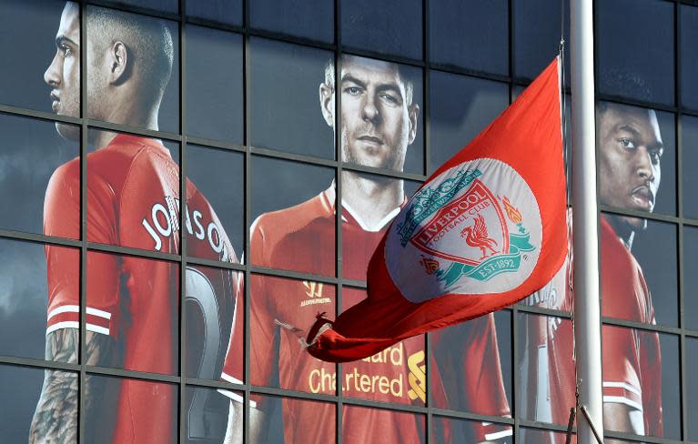 The Liverpool flag flies at half mast in front of a montage showing Glen Johnson (left), Steven Gerrard (centre) and Daniel Sturridge at Anfield on April 15, 2014 as the city prepares to mark the 25th anniversary of the Hillsborough Disaster