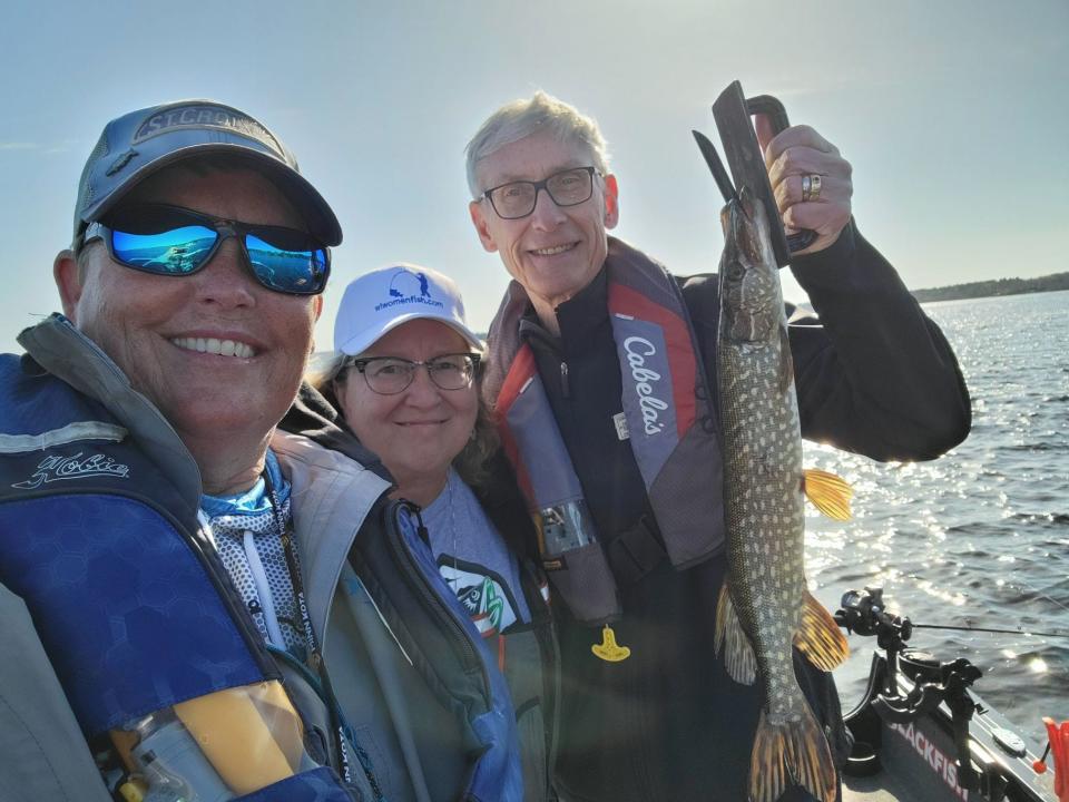 Gov. Tony Evers holds a northern pike he caught while fishing on Shell Lake Saturday with Barb Carey (left) of Oxford and Jane McMahon of Baraboo during the 2022 Governor's Fishing Opener.