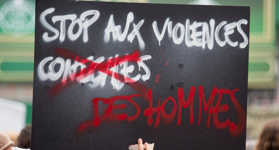 Anti-violence banner being held by protester in Paris calling for end in violence against women.