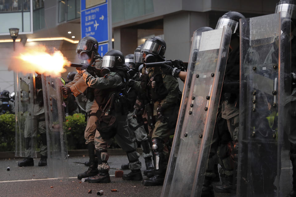 Riot police fires tear gas at protesters during a protest in Hong Kong, Sunday, Aug. 25, 2019. Police were skirmishing with protesters in Hong Kong for a second straight day on Sunday following a pro-democracy march in an outlying district. (AP Photo/Kin Cheung)