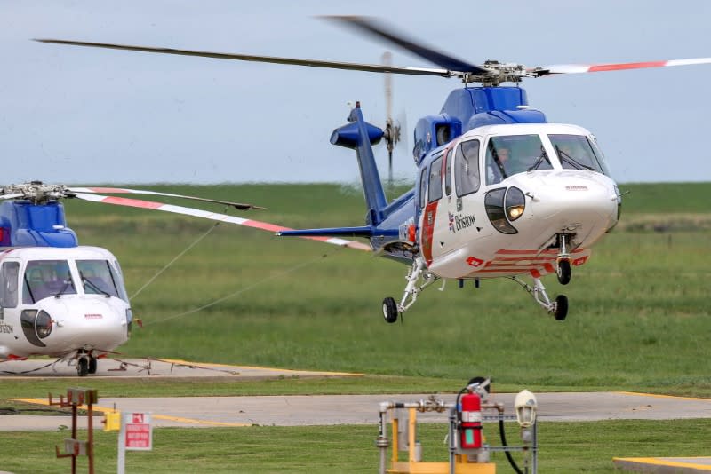 FILE PHOTO: A helicopter carrying evacuated workers from oil production platforms lands ahead of Tropical Storm Cristobal, in Galliano