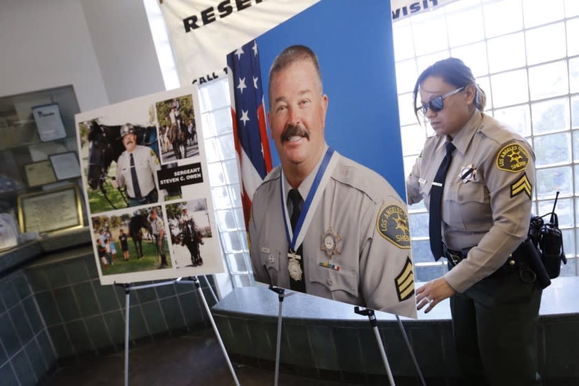 LANCASTER, CA - OCTOBER 06, 2016 - Deputy Sara Rodriguez places portraits of Sgt. Steve Owen in the lobby of the Lancaster Sheriffs HQ Thursday afternoon. Los Angeles County sheriffâ€™s Sgt. Steve Owen died Wednesday after he was shot while responding to a call about a residential burglary in Lancaster. (Al Seib / Los Angeles Times)