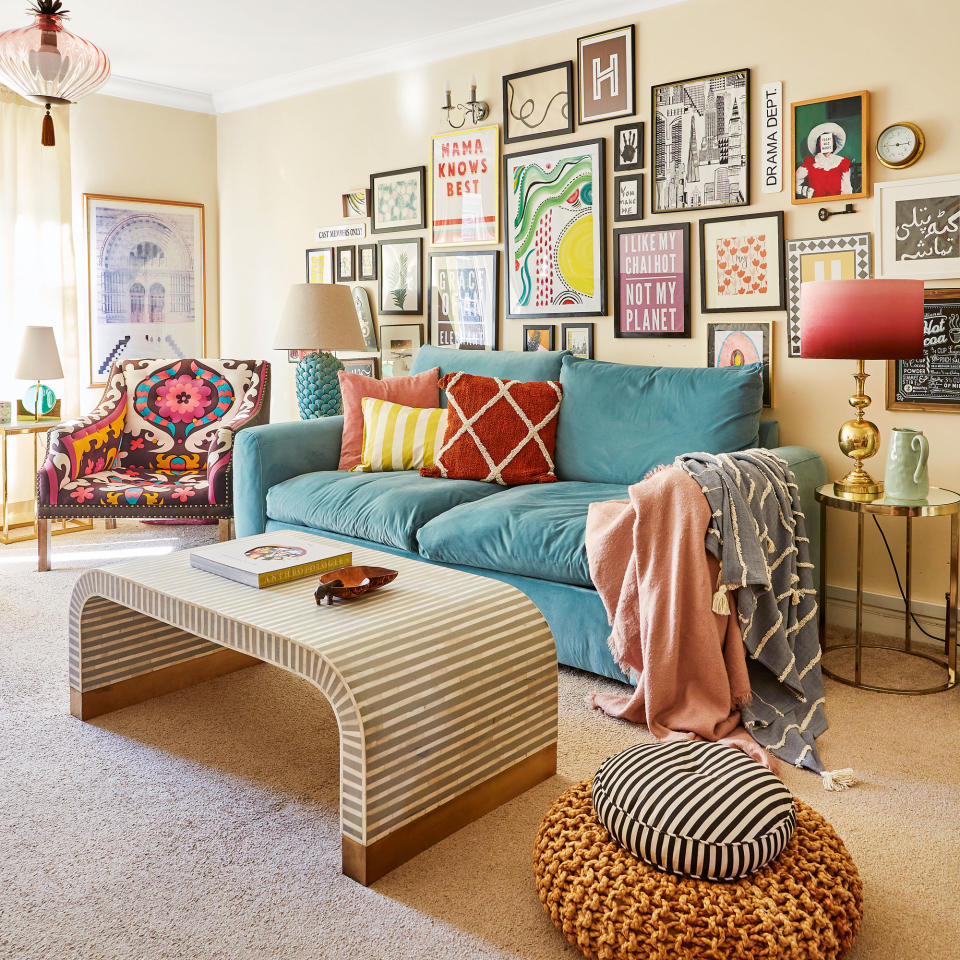 Living room with large turquoise sofa, gallery wall and curved coffee table