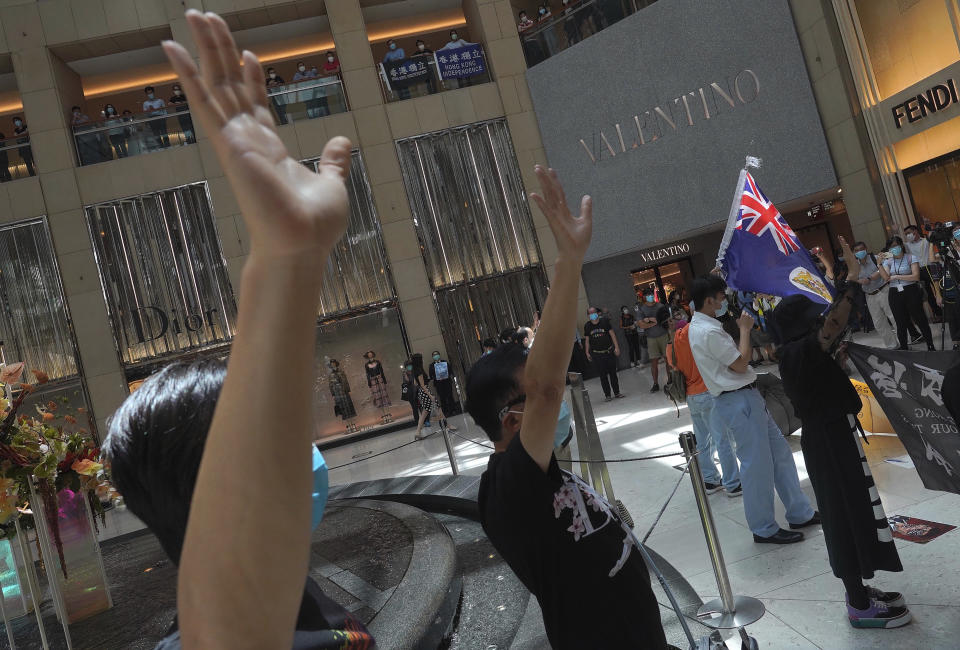 Protesters wave a Hong Kong colonial flag in a shopping mall during a protest against China's national security legislation for the city, in Hong Kong, Monday, June 1, 2020. The mouthpiece of China's ruling Communist Party says U.S. moves to end some trading privileges extended to Hong Kong grossly interfere in China's internal affairs and are doomed to fail. (AP Photo/Vincent Yu)