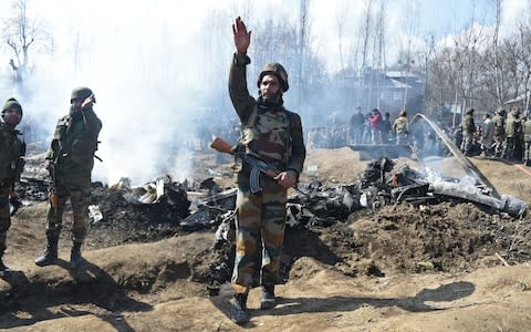 Indian soldiers gesture near the remains of an Indian Air Force helicopter after it crashed in Budgam district, outside Srinagar on February 27, 2019 - Credit: Tauseef Mustafa/AFP