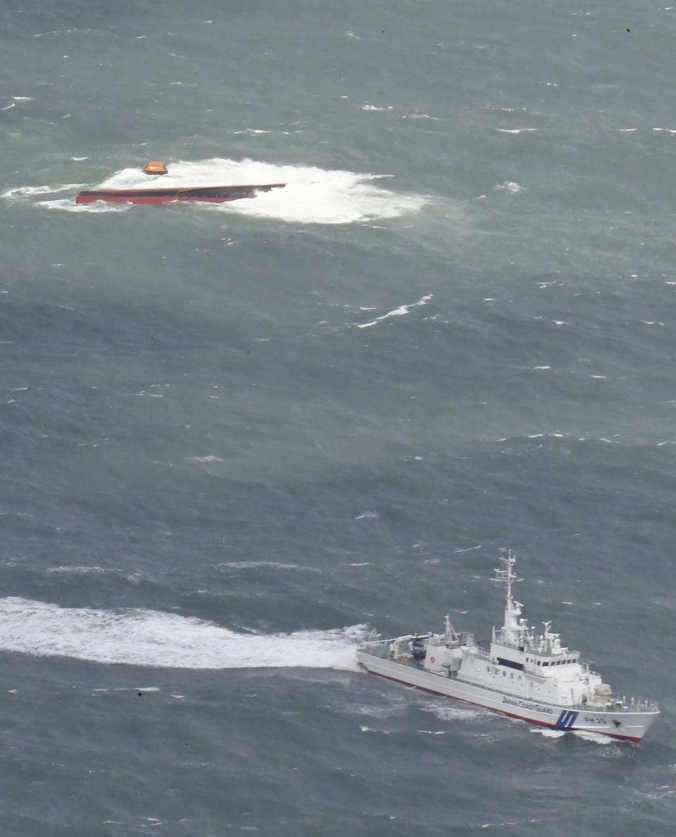 A Japanese coast guard patrol vessel, bottom, conducts a search operation near a South Korean tanker which capsized off Mutsure Island, Yamaguchi prefecture, southwestern Japan Wednesday, March 20, 2024. The coast guard said it received a distress call from the Keoyoung Sun chemical tanker, saying that it was tilting and was taking refuge near the Island. (Kyodo News via AP)