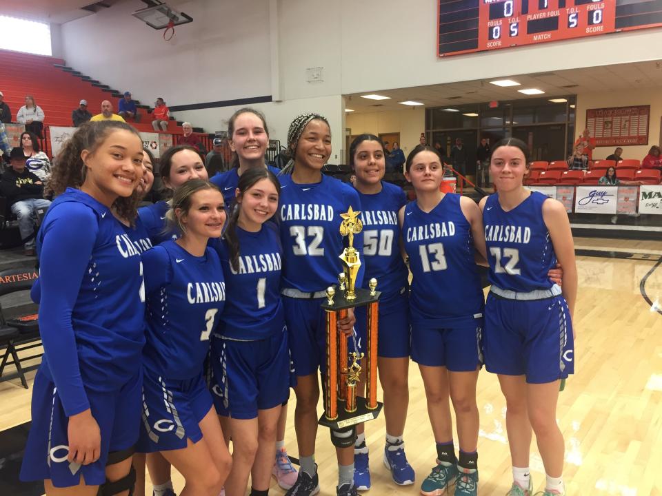 The Carlsbad Cavegirls pose with the championship trophy at the City of Champions Classic in Artesia on Dec. 3, 2022.