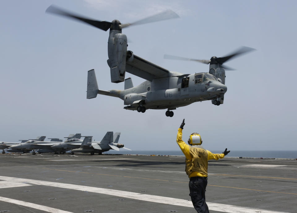 FILE -In this image provided by the U.S. Navy, Aviation Boatswain's Mate 2nd Class Nicholas Hawkins, signals an MV-22 Osprey to land on the flight deck of the USS Abraham Lincoln in the Arabian Sea on May 17, 2019. When the U.S. military took the extraordinary step of grounding its fleet of V-22 Ospreys this week, it wasn't reacting just to the recent deadly crash of the aircraft off the coast of Japan. The aircraft has had a long list of problems in its short history. (Mass Communication Specialist 3rd Class Amber Smalley/U.S. Navy via AP)