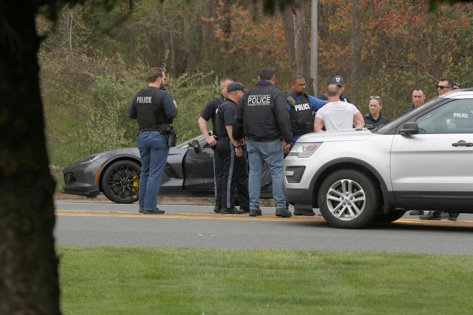 Police begin to question a man (white shirt) who led them on a chase through Monmouth County before finally being stopped on Rt 66 near the Parkway in Tinton Falls Friday, April 21, 2023.