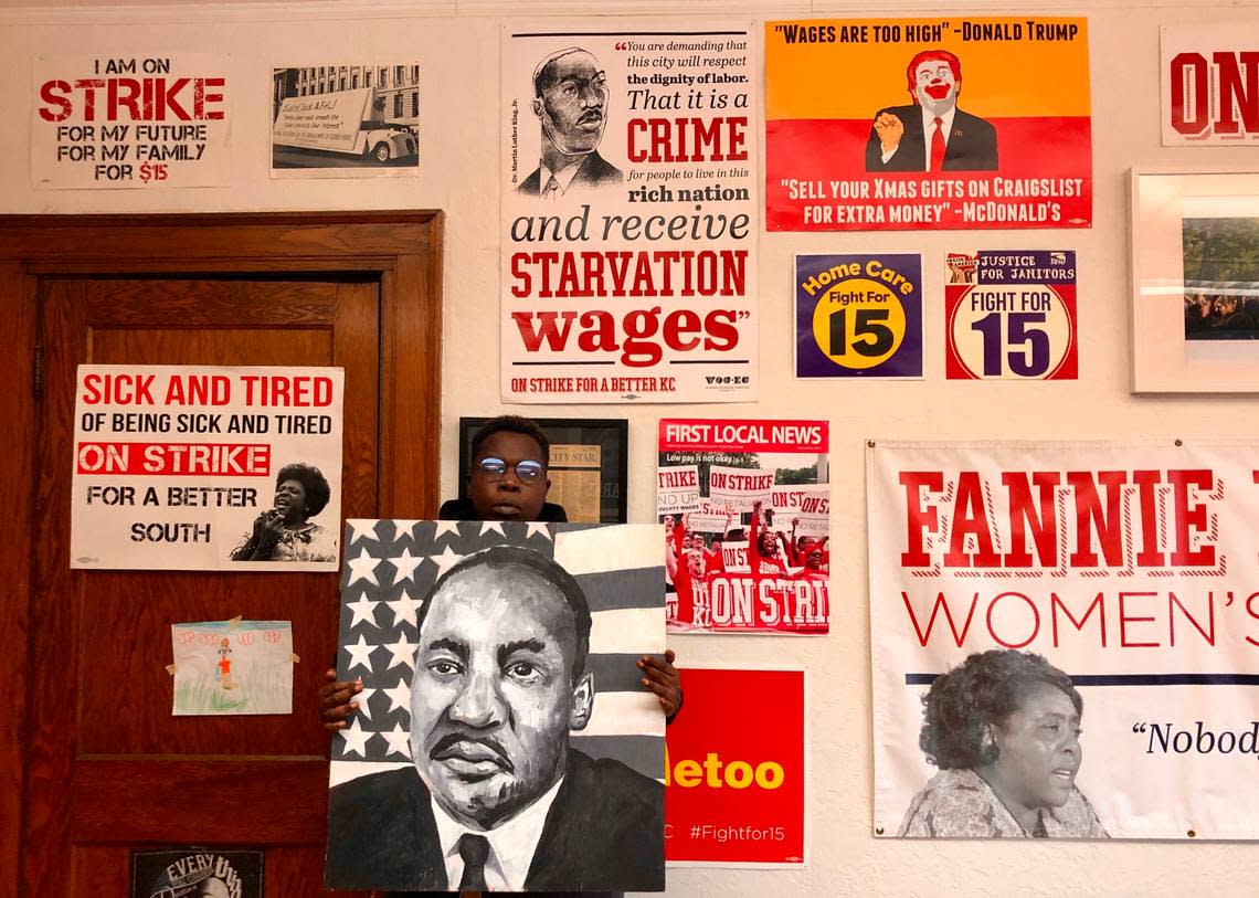 Pictures of activists fill the walls of the Stand Up KC office on Troost Avenue. Fran Marion, a leader of the group, poses there, holding a portrait of the Rev. Martin Luther King Jr.