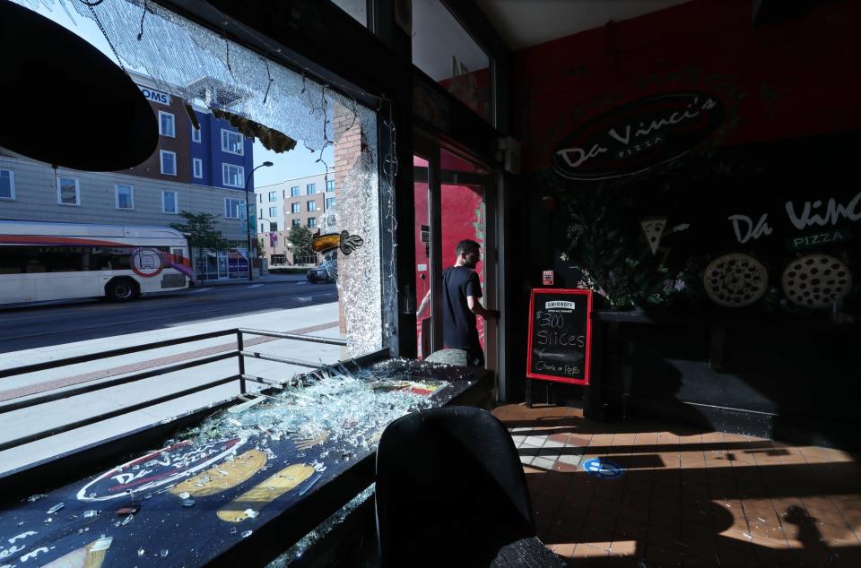 Wyatt Baer, the new owner of DaVinci's Pizza on South Main Street, enters his business to survey the damage from the protest of the police shooting of Jayland Walker Sunday night in Akron. Baer has only owned the pizza shop for two days.