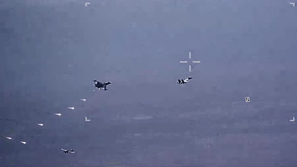 In this image from video released by the U.S. Air Force, Russian military SU-34 and SU-35 aircraft release flares in the flight path of a U.S. Air Force MQ-9 Reaper drone, lower left, on Thursday, July 6, 2023, over Syria.  - US Air Force/AP