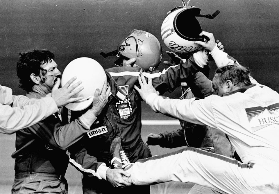 FILE - In this Feb. 18, 1979, file photo, Cale Yarborough, right, kicks and pushes Bobby Allison, center, who is catching his leg as brother Donnie, left, tries to pull his Bobby free from the fight which started after Yarborough collided with Donnie on the last lap of the Daytona 500 auto race, taking them both out of the finals in the race in Daytona Beach, Fla. The 1979 race was instrumental in broadening NASCAR's southern roots. Forty years later, it still resonates as one of the most important days in NASCAR history. (AP Photo/Ric Feld, File)